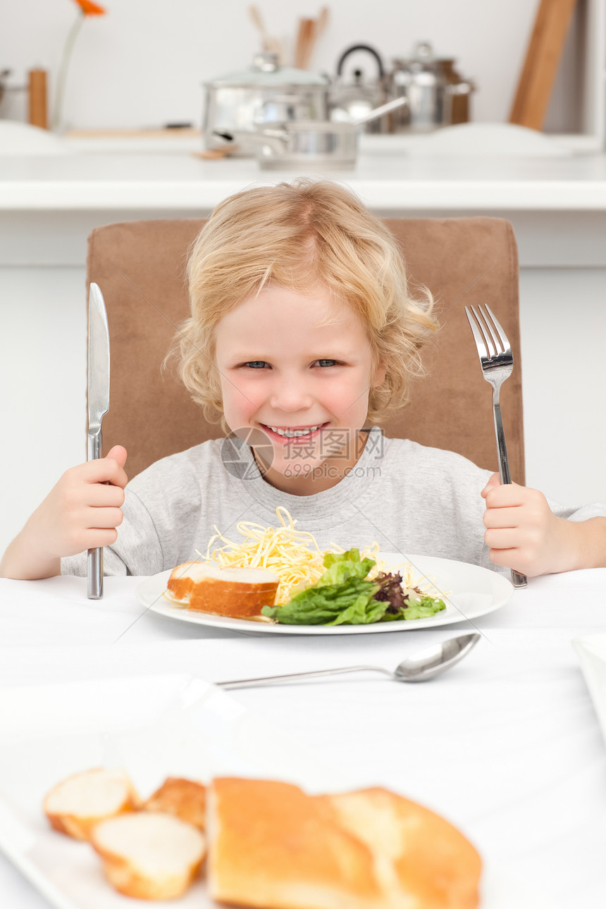 一个小男孩的肖像 准备吃意面和沙拉图片
