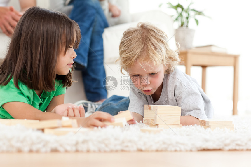 小可爱男孩玩多米诺 和他的妹妹在地板上图片