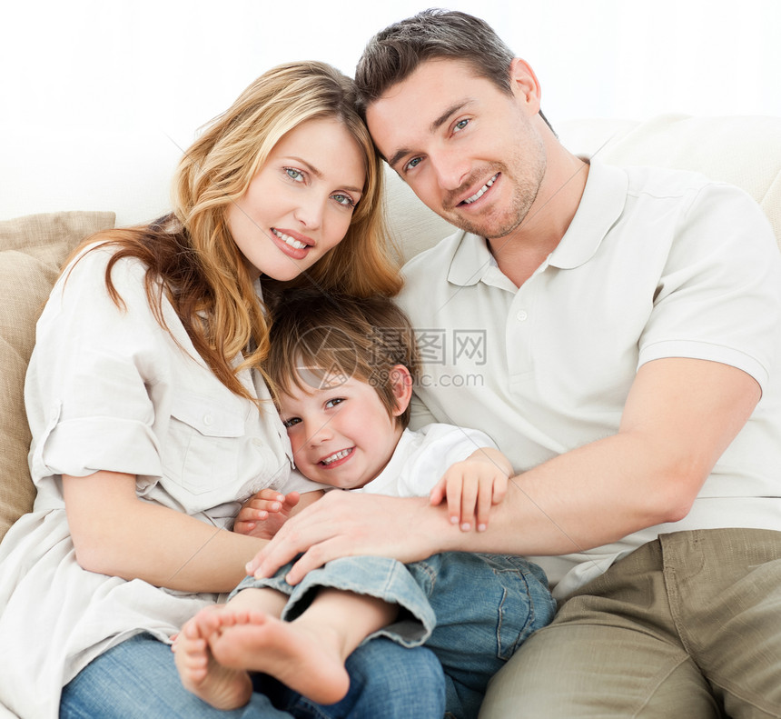 幸福的家庭在他们的沙发上儿子乐趣男人女士男生头书妻子丈夫相片童年图片