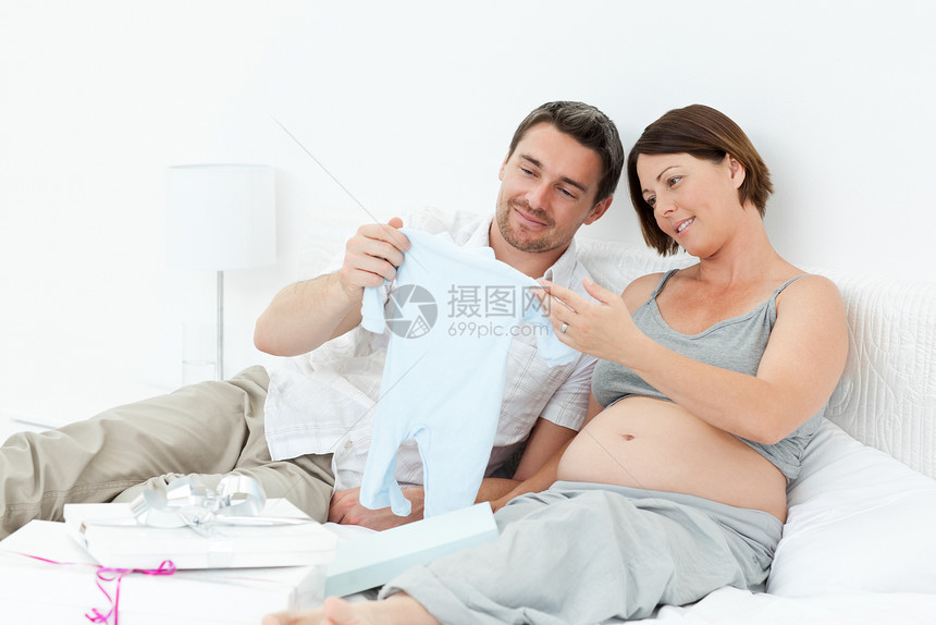 年轻未来的父母穿着乳衣怀孕女性父亲妻子微笑几个月母性母亲喜悦卧室图片