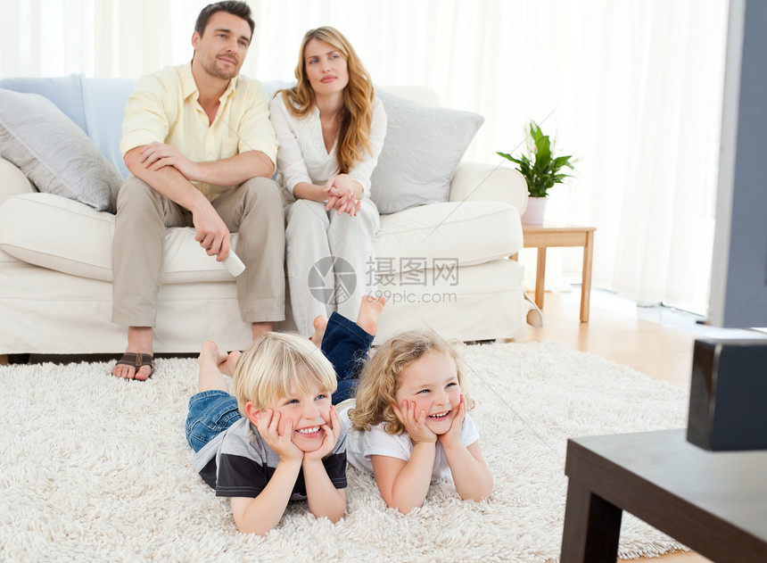 可爱的家庭观看电视女士女孩电影妈妈渠道儿子母亲幸福父亲客厅图片