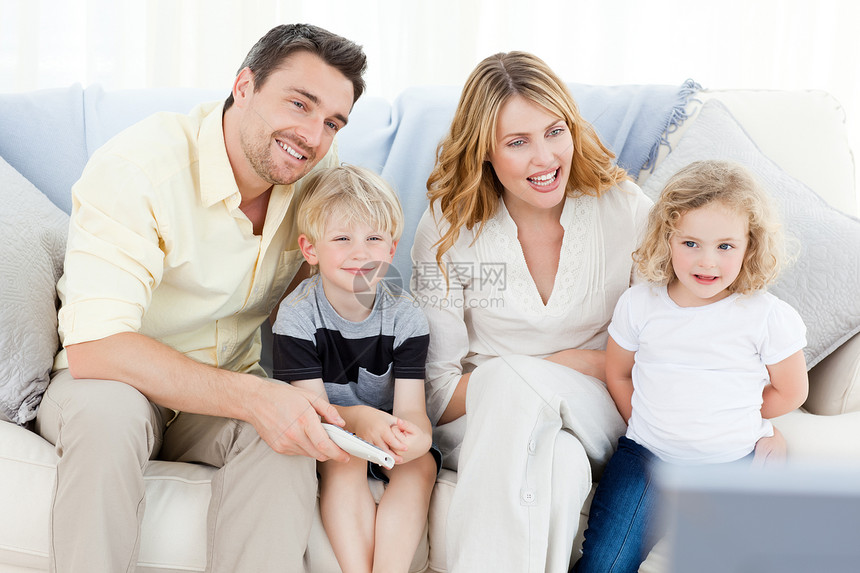 可爱的家庭观看电视食物母亲女孩乐趣幸福孩子程序长椅童年男生图片