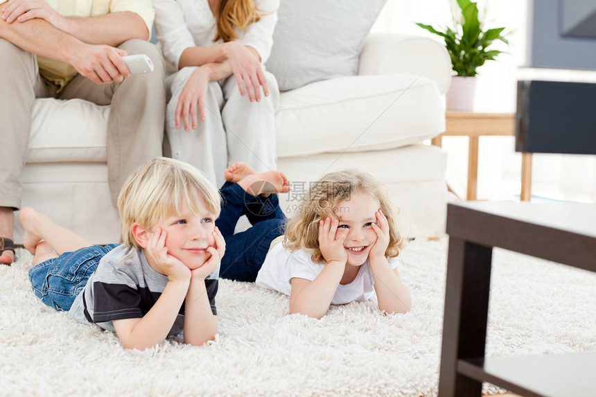 可爱的家庭观看电视沙发女士孩子食物儿子男生客厅爆米花母亲女儿图片
