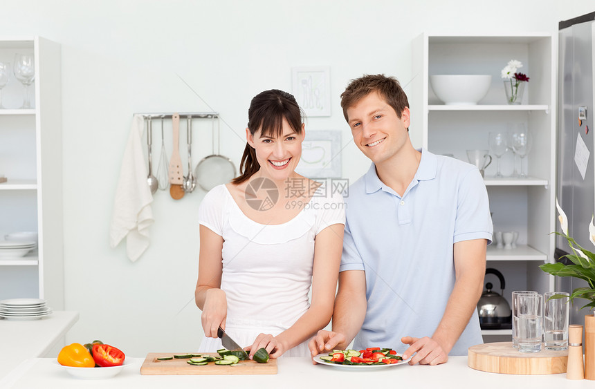 年轻一对看镜头的年轻夫妇胡椒男人勺子草药蔬菜烹饪菜肴女士香料味道图片