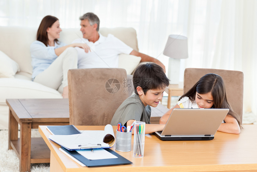 在家用笔记本电脑工作的儿童男人互联网女孩孩子们帮助女儿作业父亲爸爸父母图片