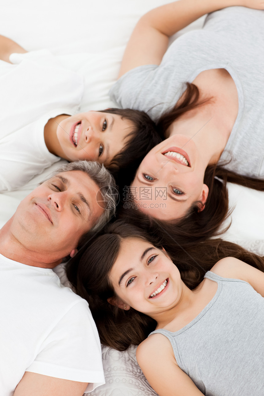 家人躺在他们的床上孩子女儿爸爸父母拥抱感情女孩家庭男性房子图片