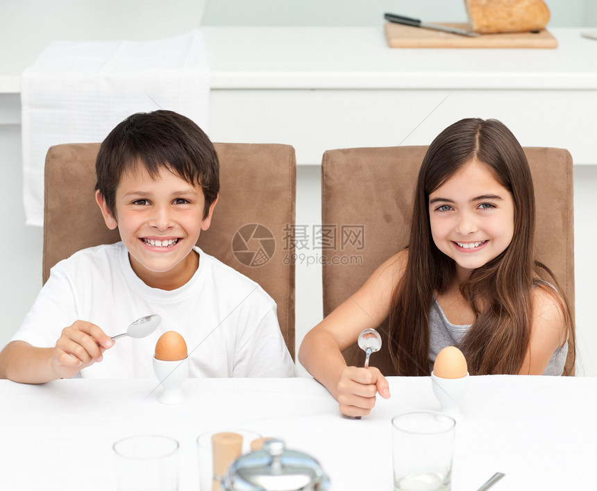 孩子们在厨房里吃早饭孩子小吃午餐快乐女孩早餐桌子青年食物勺子图片