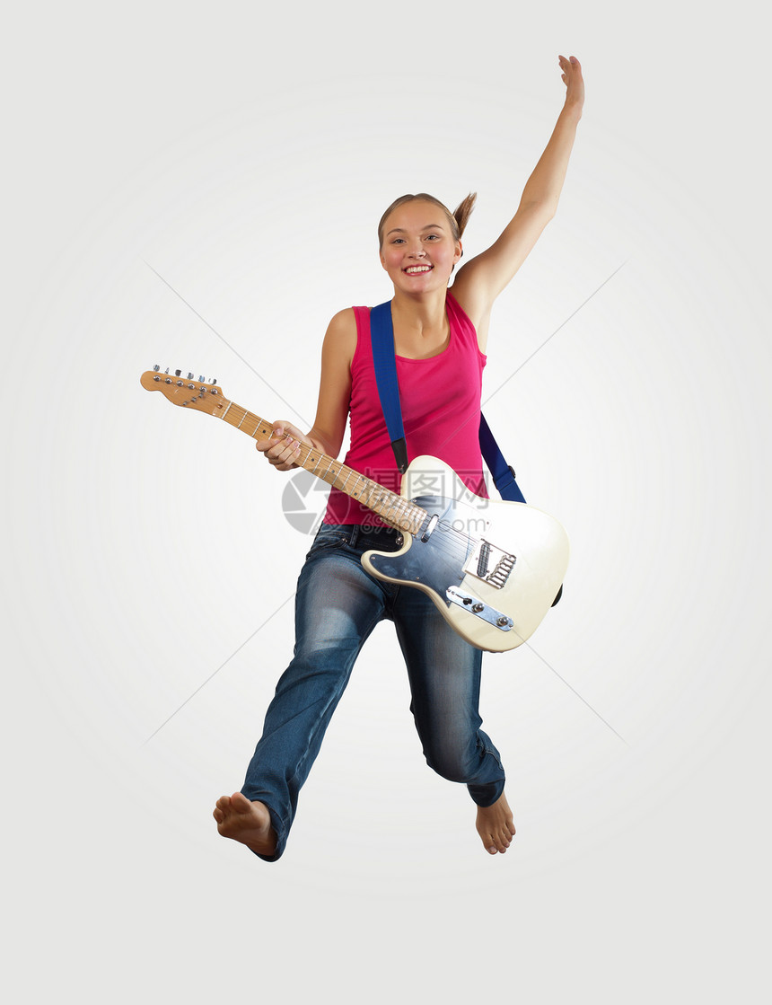 女青年玩电吉他和跳跳女士电气成人舞蹈音乐空气吉他手乐趣活力牛仔裤图片