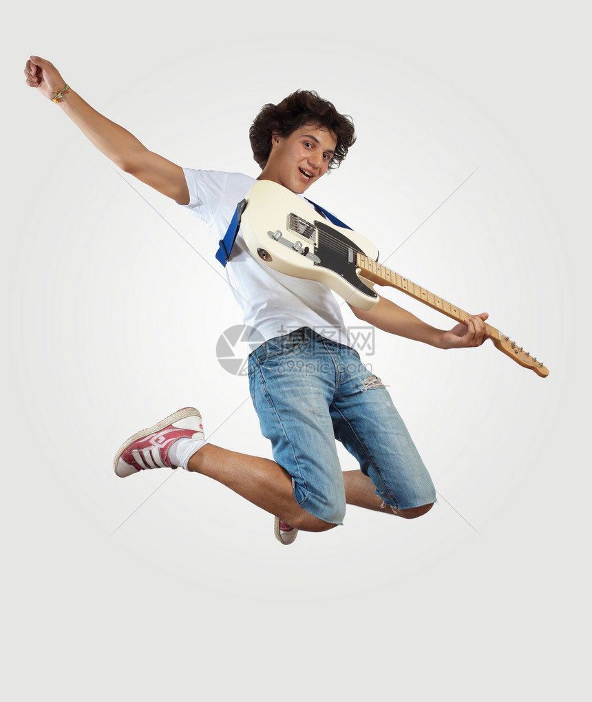 年轻人玩电吉他和跳跳摇杆流行音乐空气牛仔裤飞行舞蹈行动音乐乐队男性图片