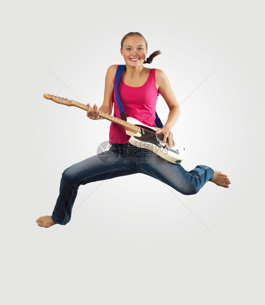 女青年玩电吉他和跳跳活力艺术家乐趣音乐家飞行乐器女性岩石低音电气图片