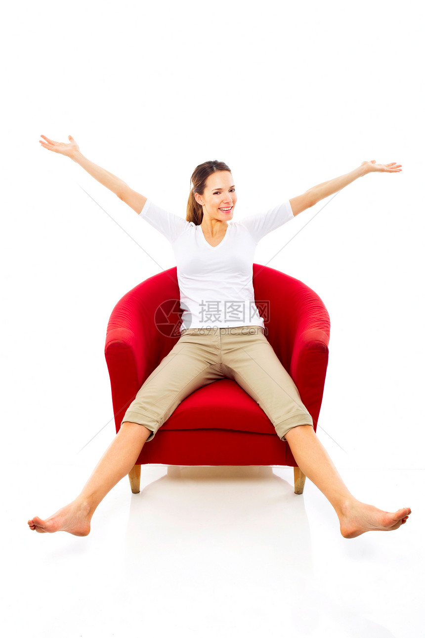 年轻女士坐在白背景工作室的椅子上女子双臂成人休闲装双腿长发头发赤脚维修站棕色图片