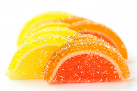 白色背景上的彩色橘子酱切片甜点食物糖果果冻片背景图片