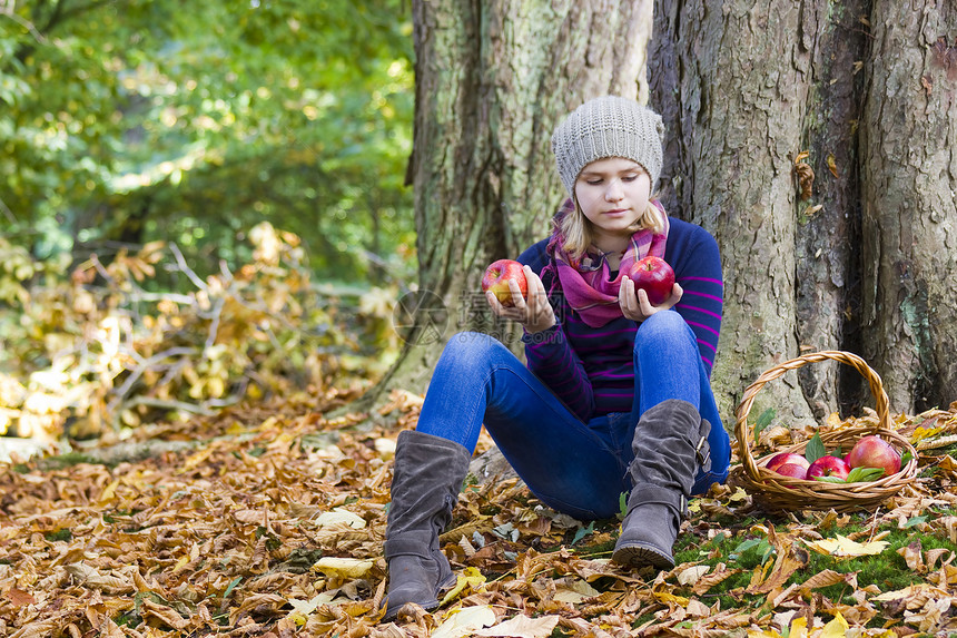 秋天花园有篮子苹果的年轻女孩树叶花园衣服孩子叶子幸福水果野餐食物公园图片