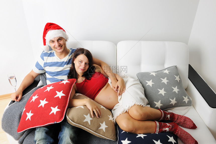 圣诞节时怀孕夫妇妻子腹部成年人丈夫生活婚姻帽子母亲沙发家庭图片