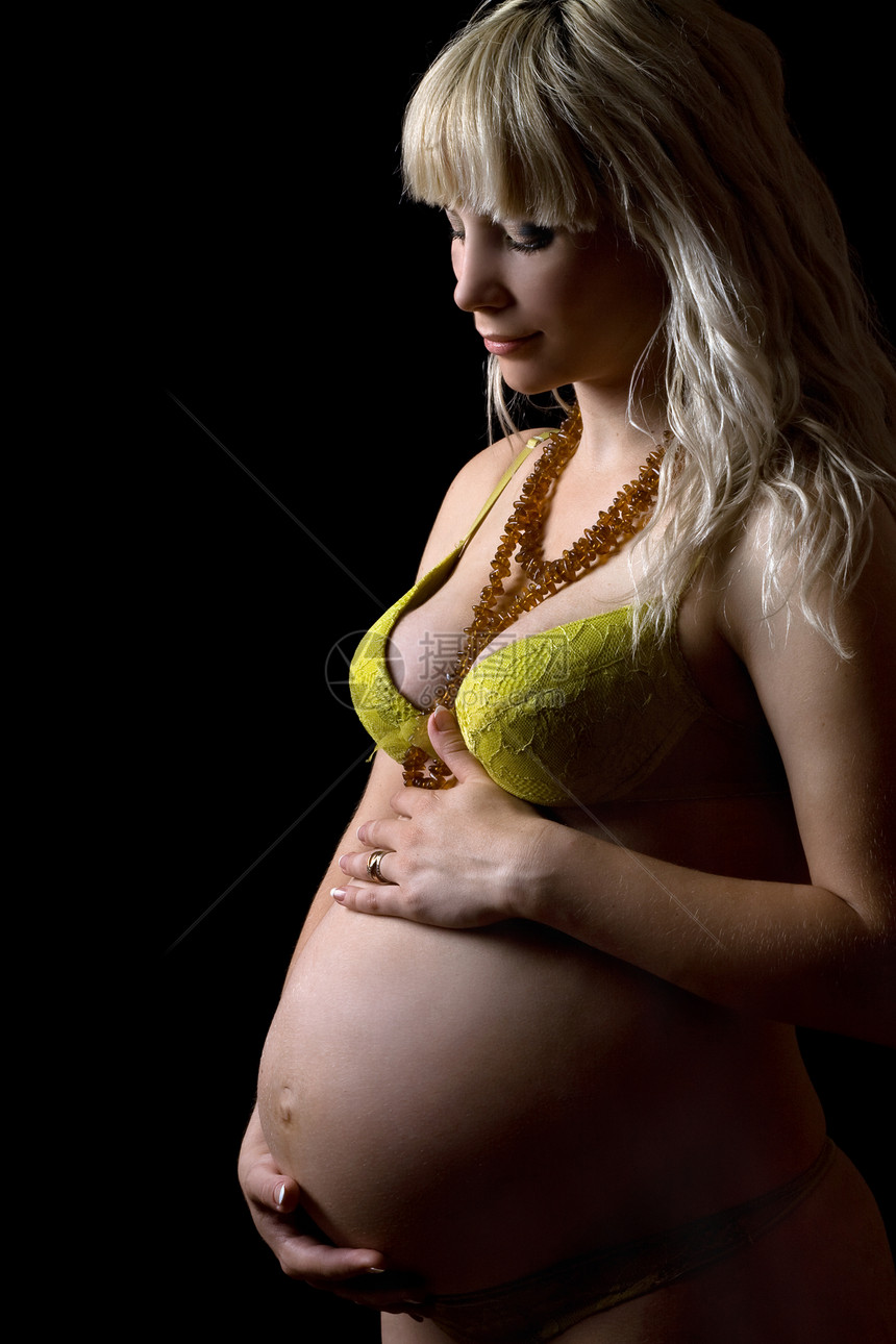 身穿黄色内衣的年轻孕妇腹部金发女郎父母产妇幸福拥抱身体女士金发工作室图片