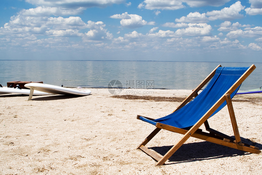 坐在海滩上的沙滩上对抗海湾和云彩图片