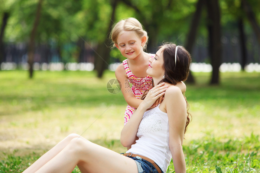 母亲和女儿在公园里亲热感情笑声乐趣女性拥抱妈妈喜悦女士微笑图片