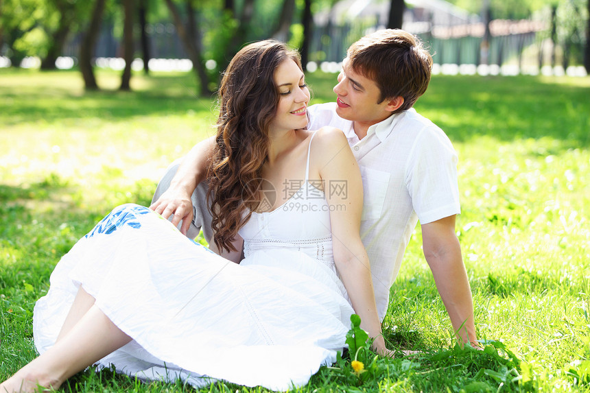 在蓝天下微笑的情侣男人家庭女孩场地拥抱女士女性公园牙科幸福图片