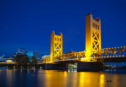 萨克拉门托的金色盖子吊桥日落城市反射铆钉首都商业金子黄色天空运输背景