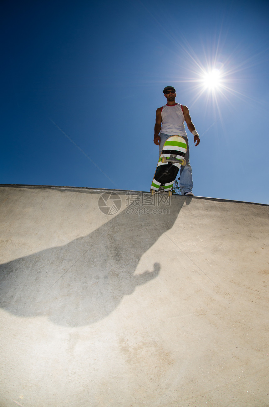 混凝土池中的滑板机青年活力水池娱乐树木城市栏杆平衡男人天空图片