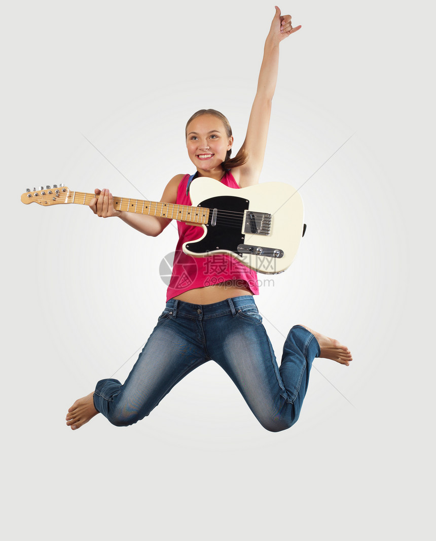 女青年玩电吉他和跳跳跳跃享受空气流行音乐旋律低音男生乐器吉他手音乐会图片