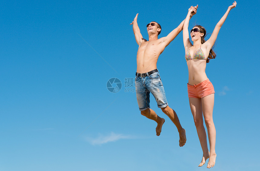年轻夫妇一起跳跃女孩胜利场地空气男生乐趣家庭女士衣服公司图片