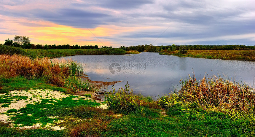 湖边的秋夕日落绿色叶子场景场地季节树叶黄色橙子环境蓝色图片