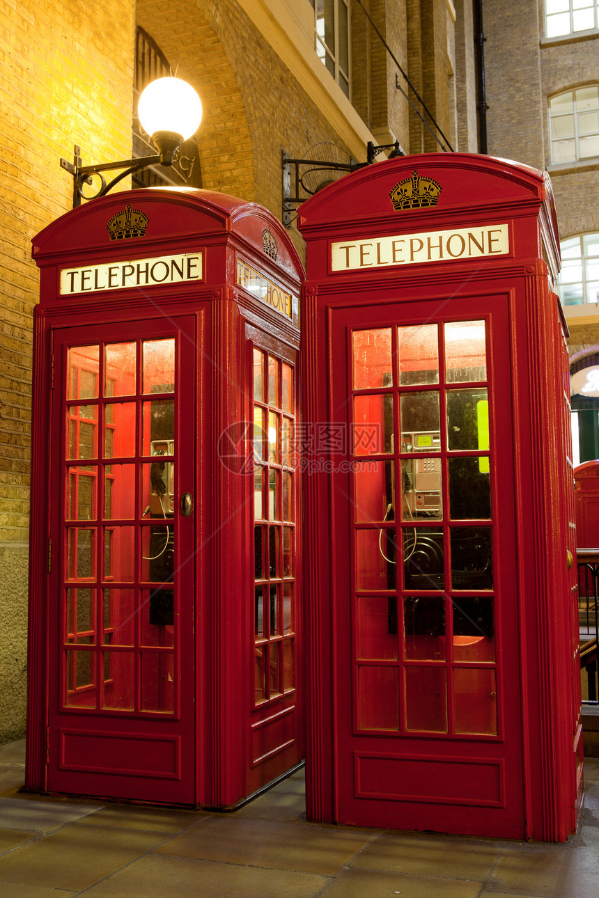 伦敦符号 2个红色电话盒 在照亮的街道上图片