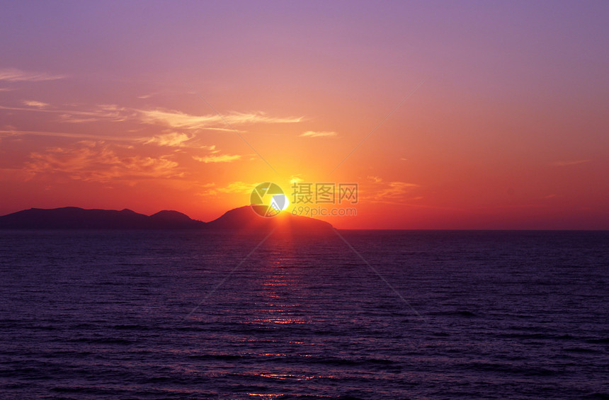 美丽的日出风景反射波浪天线海滨丘陵太阳射线天空地平线图片