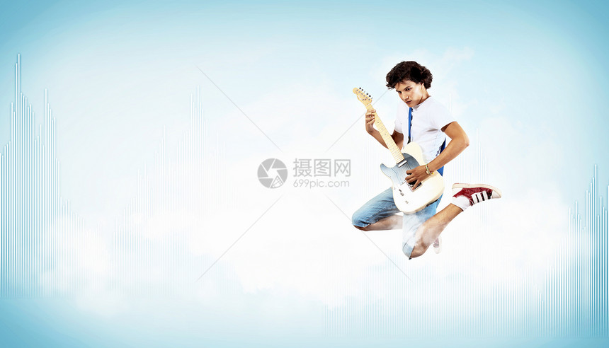 年轻人玩电吉他和跳跳男生电气流行音乐岩石行动乐器艺术家音乐会牛仔裤跳跃图片