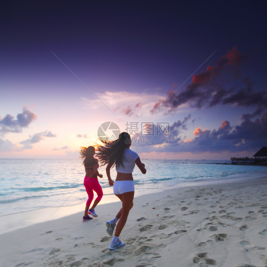 两个女人在沙滩上奔跑跑步慢跑运动装海洋运动蓝色成人女性日落赛跑者图片