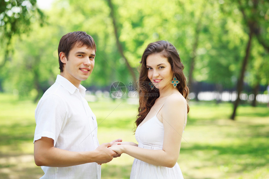 在蓝天下微笑的情侣拥抱公园男朋友女士女性幸福家庭女孩男性成人图片