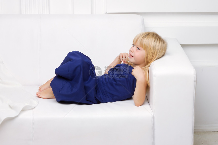 穿着蓝礼服的女孩 在白色沙发上冒充头发女性毛皮裙子休息身体家具长椅金发图片