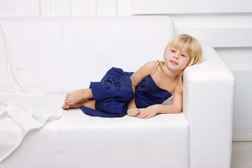 穿着蓝礼服的女孩 在白色沙发上冒充家具工作室毛皮身体金发女性裙子孩子女士图片