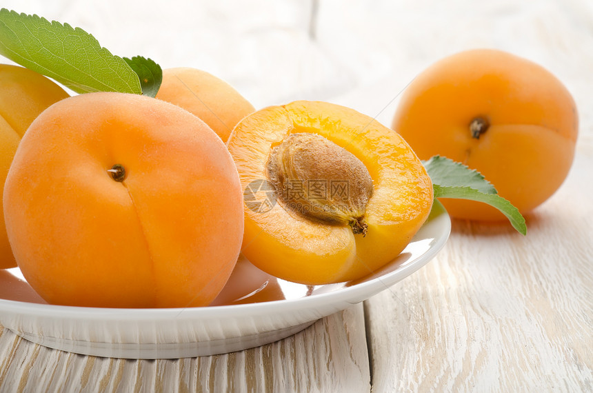 桌上的杏子食物横截面健康饮食叶子作品素食植物木头白色橙子图片