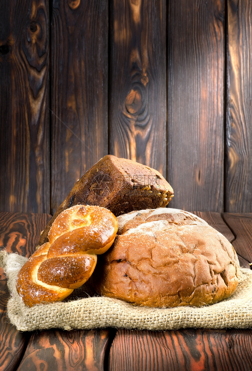 木板上的面包食物脆皮静物木头织物黑色酵母包子团体糕点图片