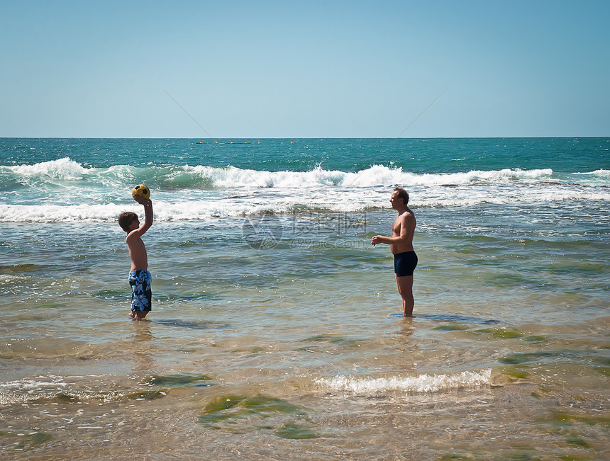 快乐的父亲和儿子在玩球旅行闲暇阳光海滩运动活力孩子父母乐趣微笑图片
