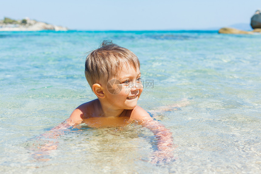 可爱的男孩在海上玩耍微笑海洋幸福活动快乐假期旅行热带竞赛蓝色图片