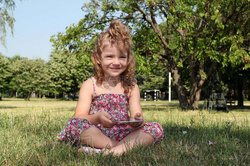 公园里有平板电脑的小女孩图片