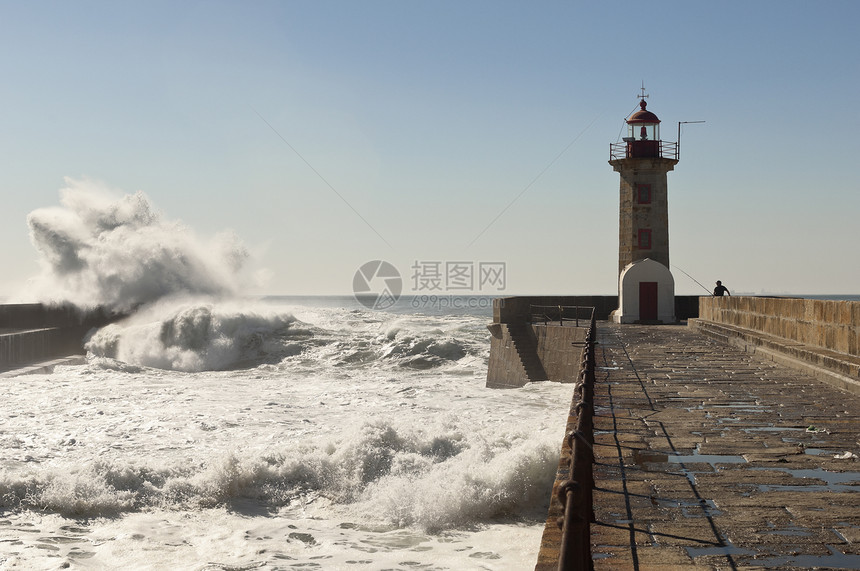 灯塔历史性冲浪人行道石头天空海浪地标安全海岸行人图片