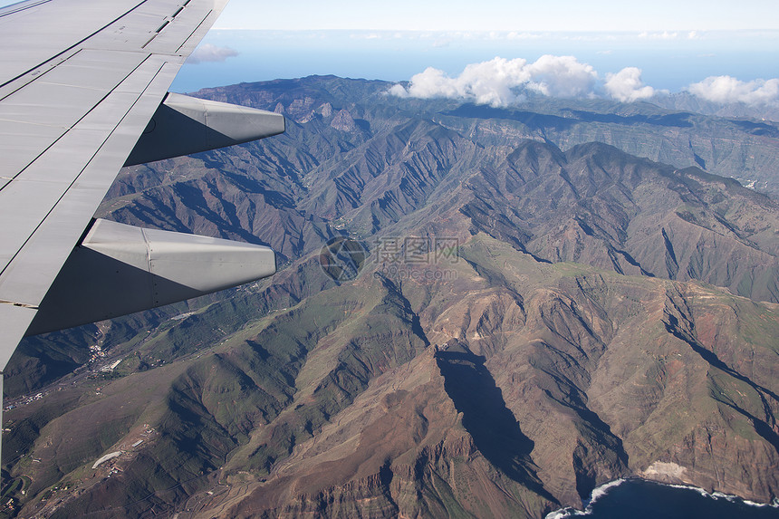 从La Gomera的飞机上查看白色热带波浪空气山脉房屋天空金属海滩火山图片