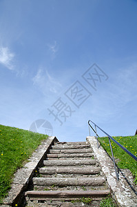 古老的楼梯蓝色栅栏城堡绿色天空黄色花朵石灰石背景图片