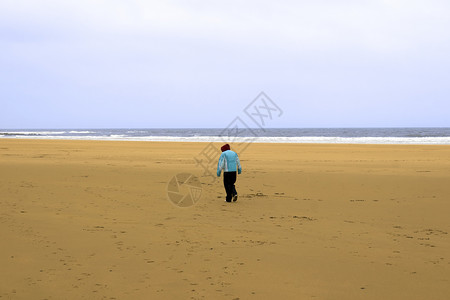 单身女孩在沙滩上与寒风相对背景图片