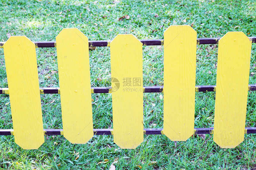 绿色草地上的黄黄色木栅栏图片
