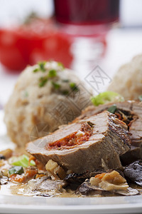 堆满了面包卷子的猪肉片饺子美食桌子酒杯蔬菜熏肉草本植物盘子餐厅烹饪背景图片