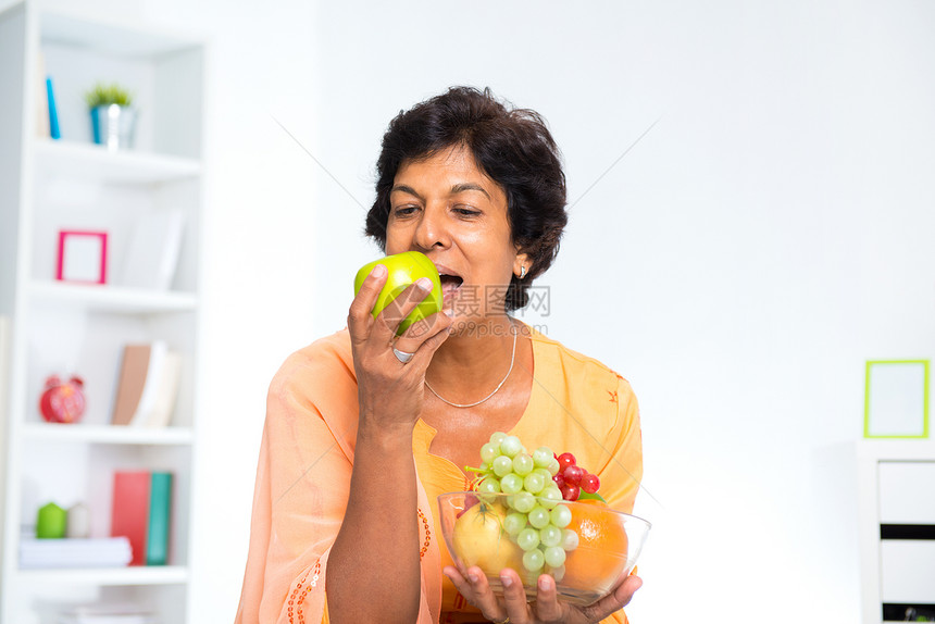 食水果的成熟印度妇女图片