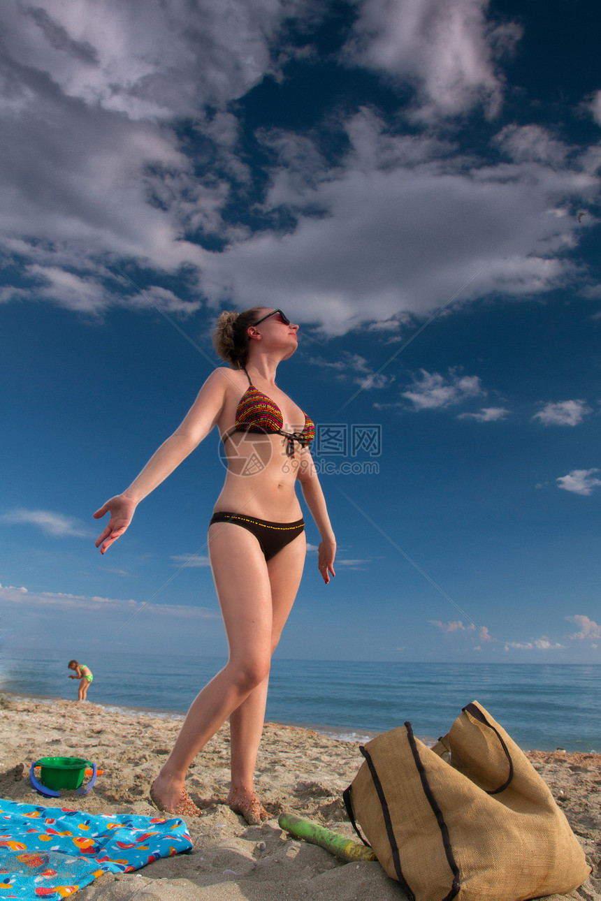 在海边放松金发女郎孩子棕褐色太阳镜泳装天空图片