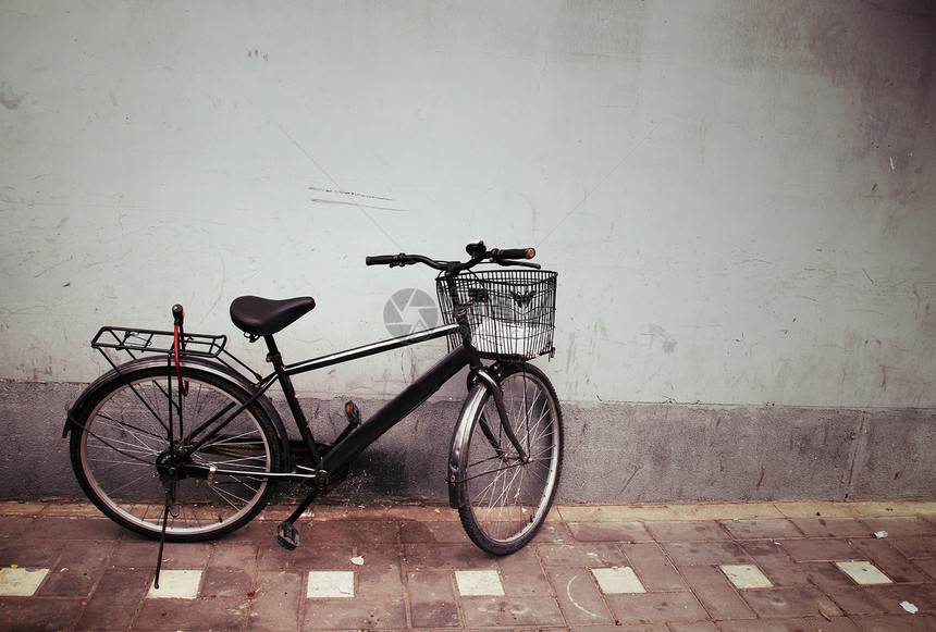 旧自行车对墙壁农场女孩们车轮旅行树叶金属街道国家古董场景图片