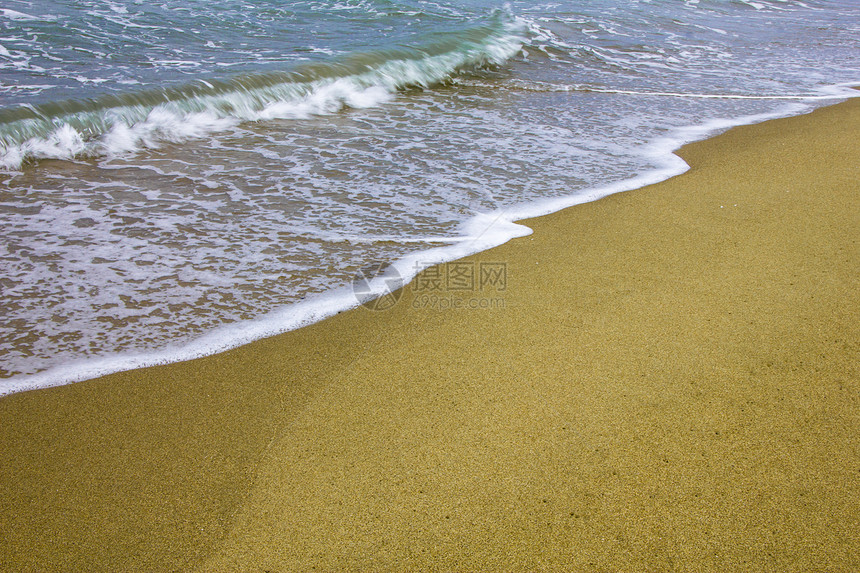 日落时金色海滩沙沙海浪泡沫支撑白色气泡蓝色对角线海洋海岸图片