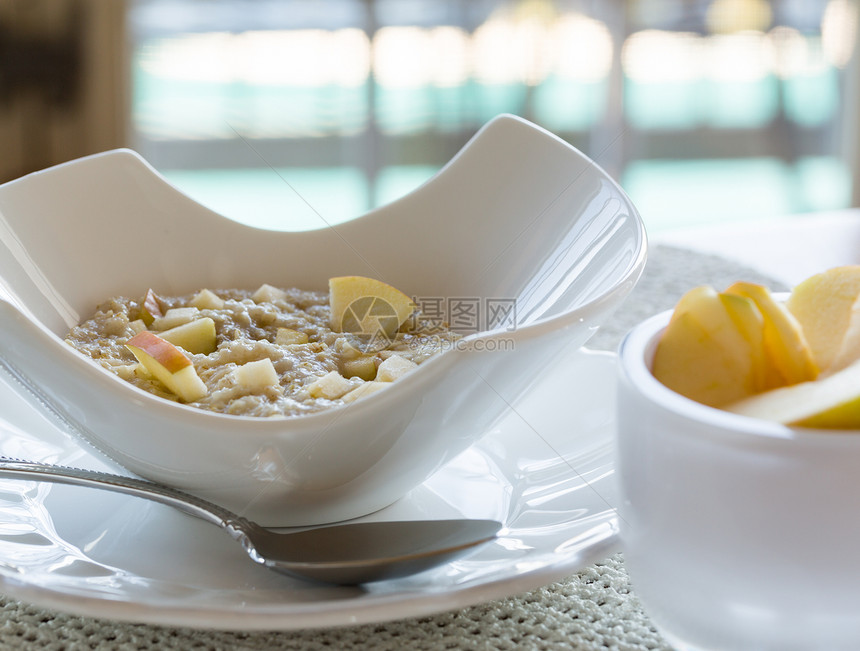 现代白色碗中的燕麦早餐纤维营养宏观粗粮陶器果味薄片勺子麦片谷物图片